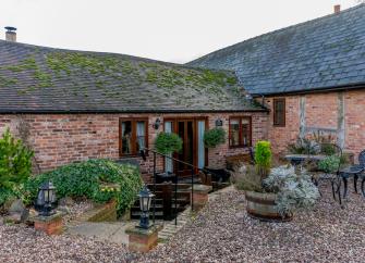 L-shaped brick exterior of a barn conversion to form a rustic holiday home in Herne Bay