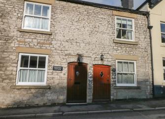 Double-fronted exterior of a stone-built holiday cottage in Buxton