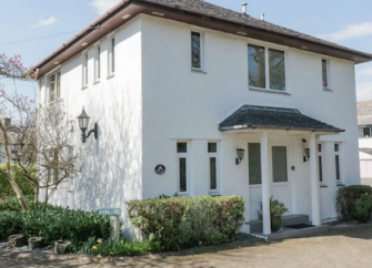 A detached period housewith a pillared portico entrance is surrounded by a mature garden.