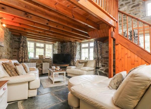 A lounge wit flagstone slate floors with stairs to a mezzanine floor above. 