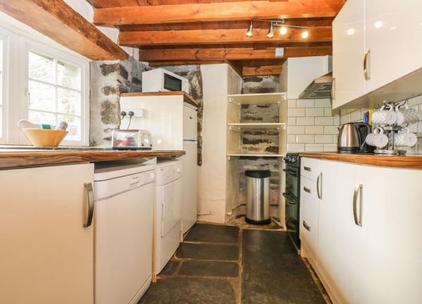 A galley-style kitchen with integrated dishwasher, washing machine and cooker.