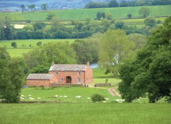 A small country house in Cumbria surrounded by trees and parkland