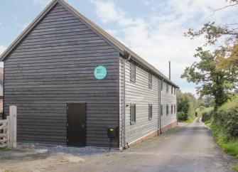 Exterior of a long wooden barn conversion near Shrewsbury