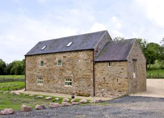 Exterior of a 2-storey, stone-built,  barn conversion in a rural Peak District location.