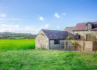 Exterior of a rural holiday cottage in Abersoch surrounded by green fields