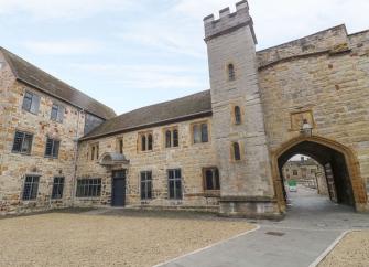 Exterior of Taunton Castle with a large arch converted to luxury holiday apartments
