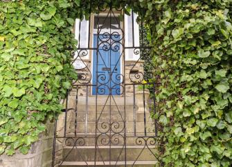 Stone steps led up to the front door of a Victorian houe iin Skipton. An iron-barred gate stand at the bottom of the steps flanked by an ivy hedge.