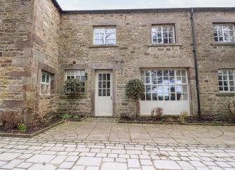 A stone-built Lancashire holiday rental with two bayleaf trees outside the front door, overlooks a flagstone courtyard