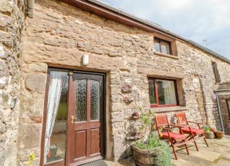 A 2-storey, stone-built holiday cottage in Cumbria overlooking a sunny courtyard