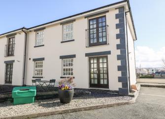 End of terrace holiday cottage with large windows and Juliet balcony.