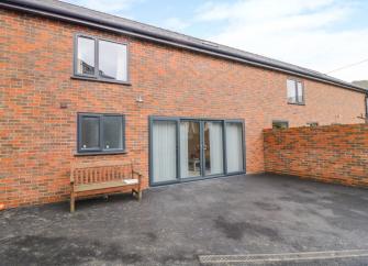 Brick-built exterior and courtyard of a Caersws holiday cottage on a farm
