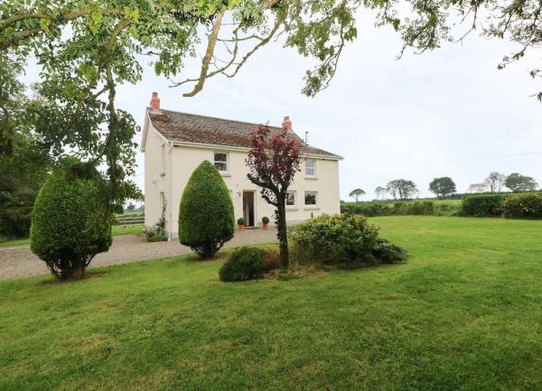 A detached rural holiay cottafge surrounded by lawns and open countryside.