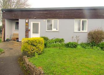 A single-storey Somerset holiday cottage in Blue Anchor overlooks a lawned garden.