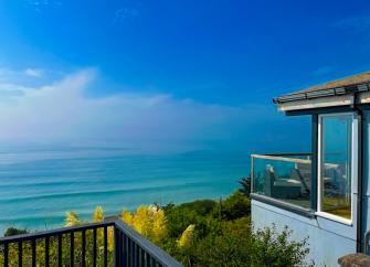 Ocean view from the glass-windowed deck of a clifftop holiday cottage in Downderry