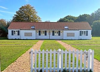 A single-storey holiday cottage on Osea Island overlooks a large lawn.