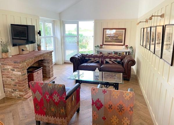 Lounge with sofas, armchairs, fireplace and TV.