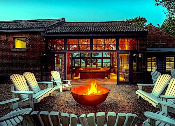 Terrace with fire pit surrounded by twin-seat chairs.