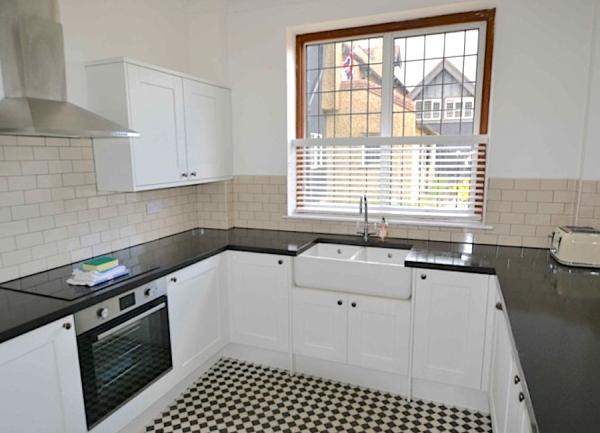 A fitted kitchen with oven, toaster and butler sink.