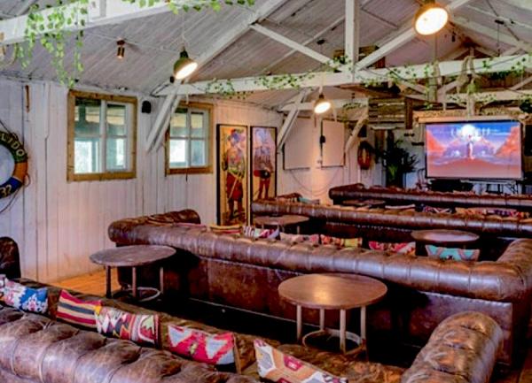 Cinema lounge with 8-seat sofas and screen.