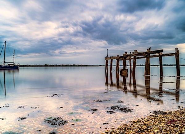 An ancient wooden jetty on the sea shore.