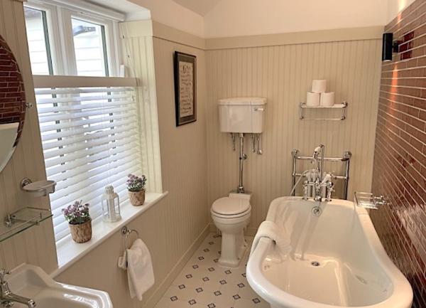 Bathroom with bath, WC and heated towel rail.