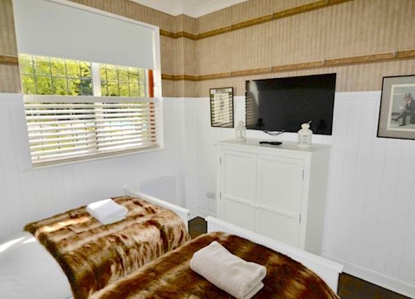 Twin bedroom with beds, chest-of-drawers and TV.