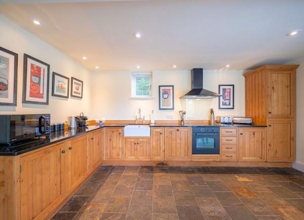A luxury kitchen with pine units with integrated oven, fridge-freezer, dishwasher and a butler sink.