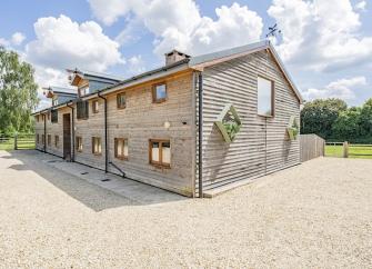 Exterior of a contemporary wood-clad barn conversion comprising 3 New Forest holiday cottages