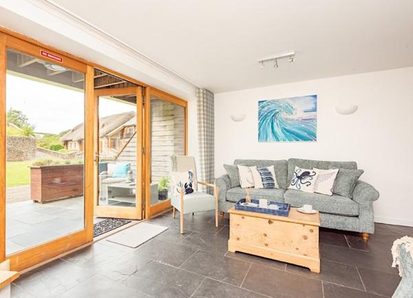 Lounge corner with sofa and open French windows to a garden terrace.