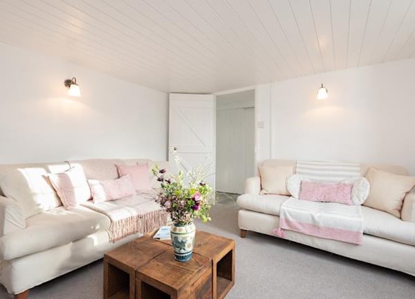A cottage lounge with twin leather sofas and coffee table.