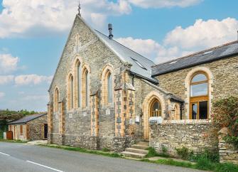 Chapel conversion exterior with tall arched windows near Polruan