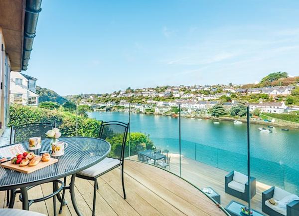 A 1st floor deck with an outdoor table overlooks the Noss Mayo estuary.