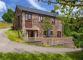 Exterior of an Exmoor Barn conversion on a bend in an empty country lane.