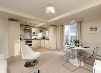 Open plan room containing a kitchen and dining area.