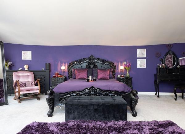 Double bedroom with an ornately-carved double bed with bedside cabinets and lamps.