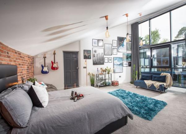 Double-bedroom with king-size bed, sofa and floor to ceiling windows.