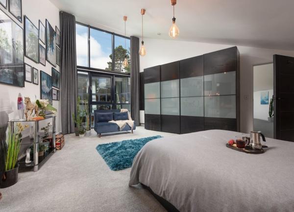Double bedroom with fitted wardrobes, bed, dressing table and a sofa.