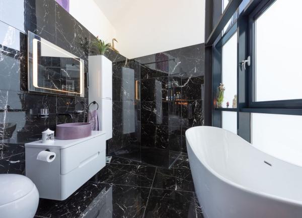 Contemporary bathroom with a stylish bath, sink and WC on a marble tiled flor.