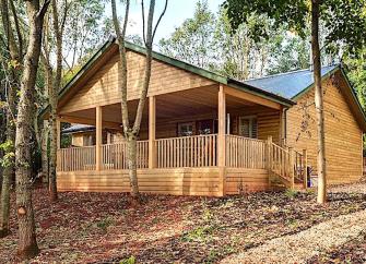 Exterrior of an eco lodge with a  covered deck and hot-tub.