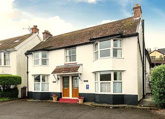 Exterior of a 2-bedroom, semi-detached holiday home with parking spaces.