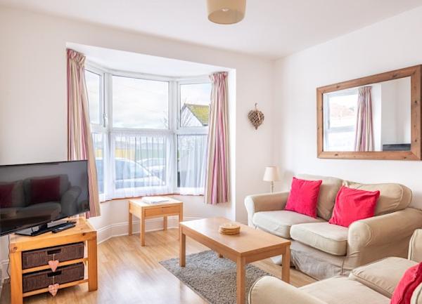 Lounge with bay window, TV, 2 sofas and 2 coffee tables.