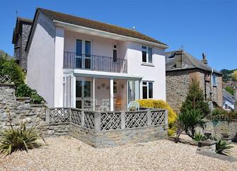 Exterior of a modern detached house with covered balcony.