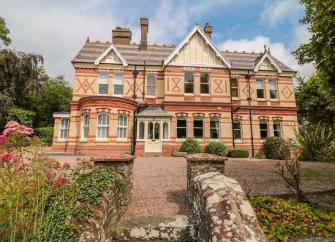 Large, 2-storey, Victorian house with a tree-lined garden