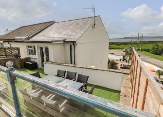 A countryside bungalow with a view of the sea in the background.