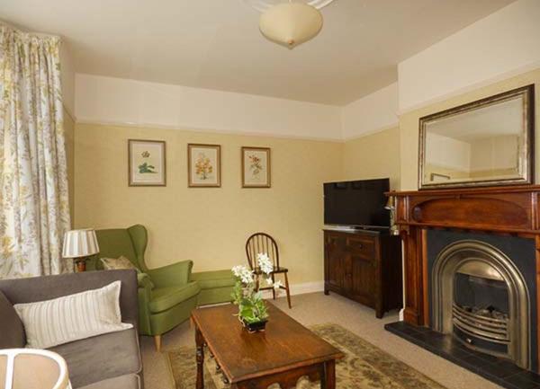 Lounge with an open fireplace, sofa, armchair and coffee table.