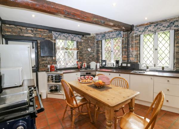 Spacious kitchen with modern fitted units, a range cooker, full-height fridge freezer and a microwave.