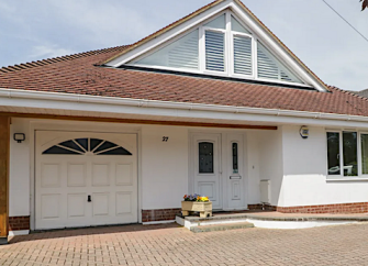 Exterior of a modern chalet bungalow with block-paved drive.