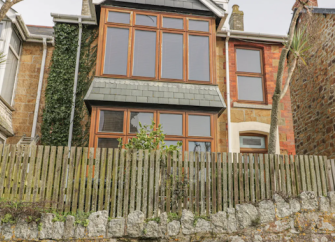 Exterior of a terraced holiday cottage in Newquay with bay windows.