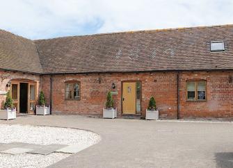 Exterior of a slate-roofed barn conversion overlooking a courtyard in Shropshire.