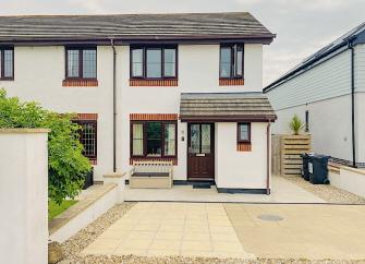 A modern semi-detached Cornish holiday cottage with block-paved drive for car.